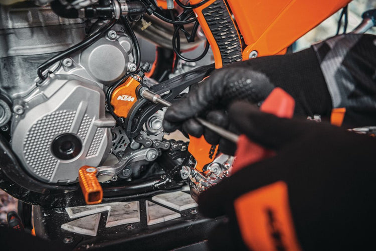 A professional mechanic performing precision maintenance in an authorised workshop, representing our comprehensive motorcycle service and repair excellence.