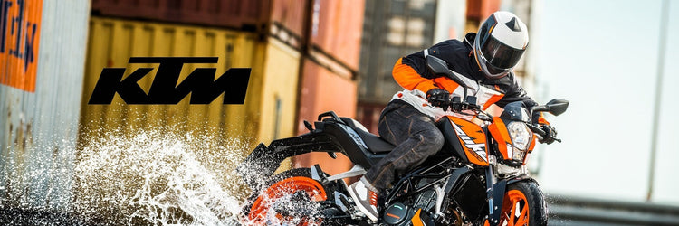 Person riding a KTM Duke motorcycle, available from Cyclespot Group New Zealand, through water with shipping containers in the background