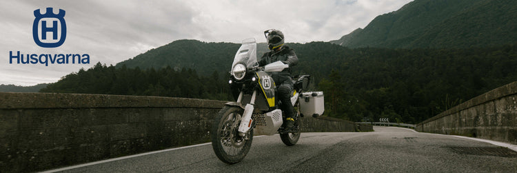 Person riding a KTM Duke motorcycle, available from Cyclespot Group New Zealand, through water with shipping containers in the background