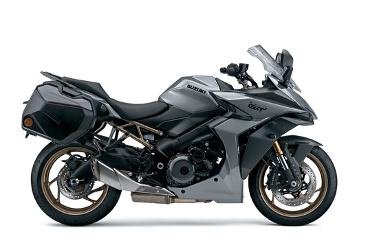 A silver and black 2025 Suzuki GSX-S 1000 TRQ motorcycle with side panniers, shown from a side profile on a white studio background.