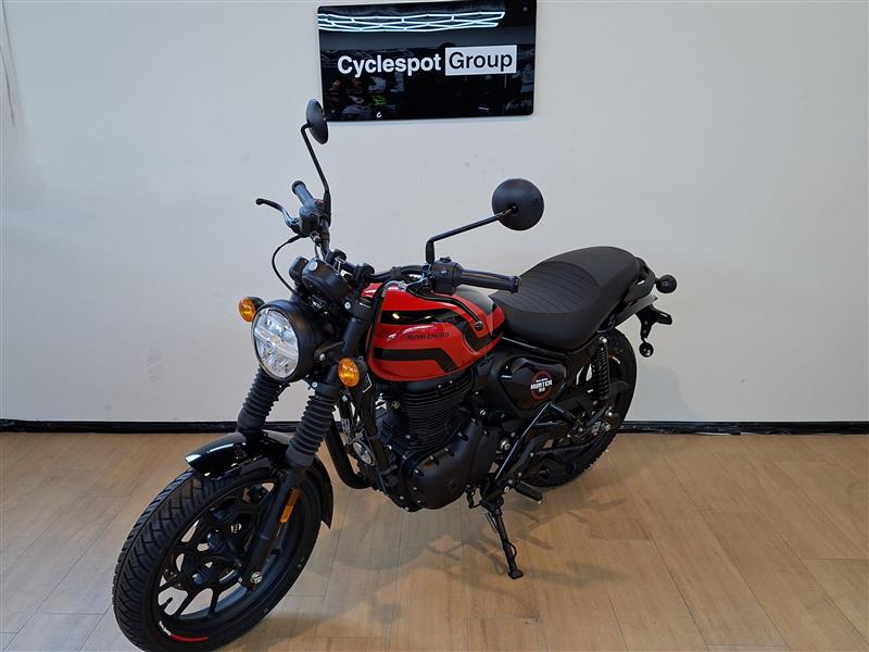 Load image into Gallery viewer, A red and black street motorcycle displayed indoors on a wooden floor against a white wall, with a visible 'Cyclespot Group' sign on the wall behind it.
