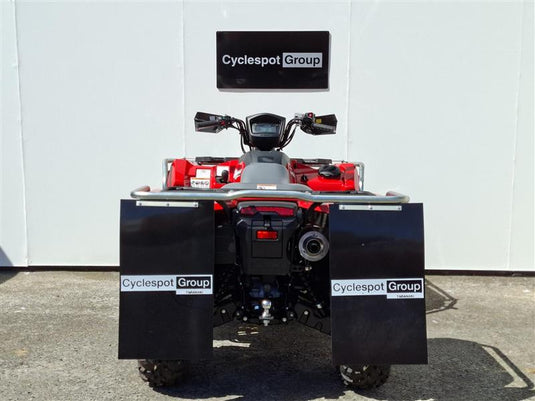 A red and black 2026 Suzuki KingQuad  LT-A500 all-terrain vehicle (ATV) is photographed from the rear, positioned in front of a white wall with a 'Cyclespot Group' sign. The vehicle features large black mudguards with 'Cyclespot Group' logos and a visible rear license plate.