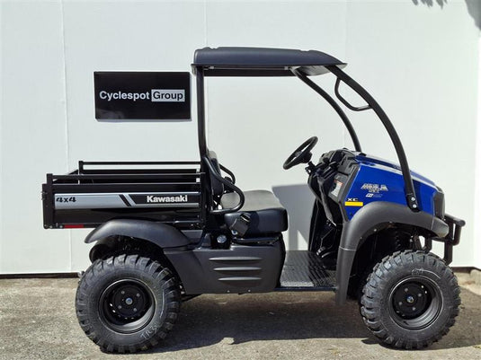 A 2017 Kawasaki Mule KAF 400 KH 4x4 utility vehicle with a black roll cage and cargo bed, parked outdoors against a white wall. The vehicle features a blue front hood and a black 'Cyclespot Group' sign mounted on the rear side.