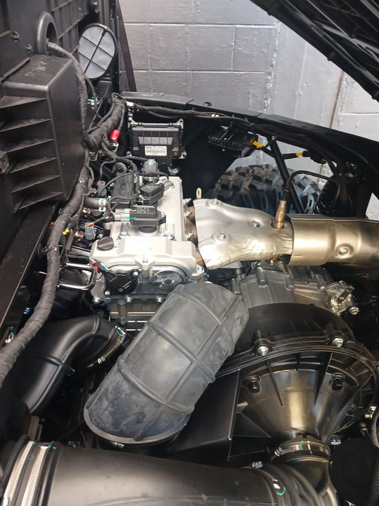 Close-up of a vehicle's engine and exhaust system.