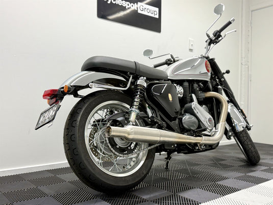 Motorcycle on a checkered floor with a white wall in the background