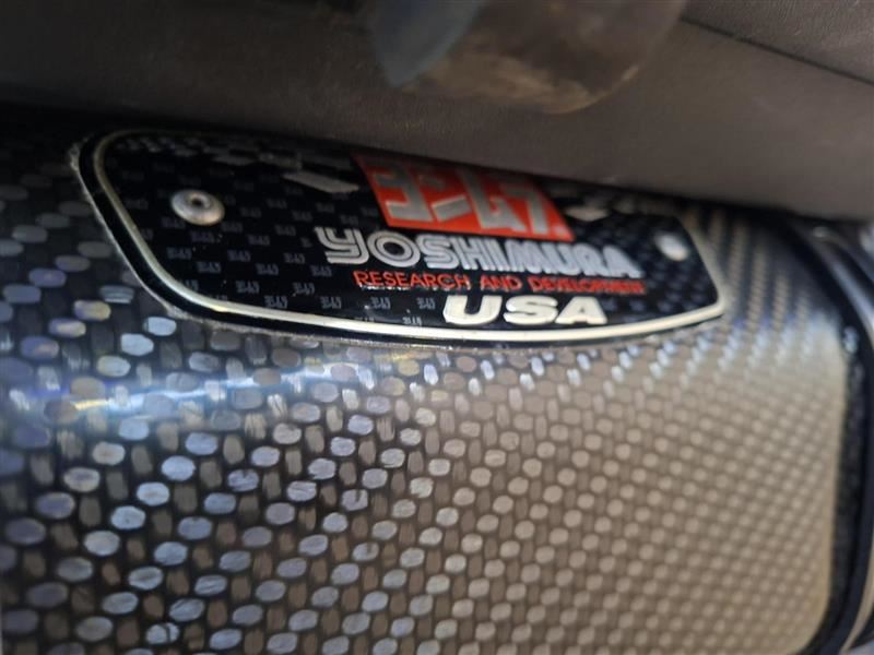 Load image into Gallery viewer, Close-up of a carbon fiber textured panel with a metallic badge reading Yoshimura Research and Development USA.
