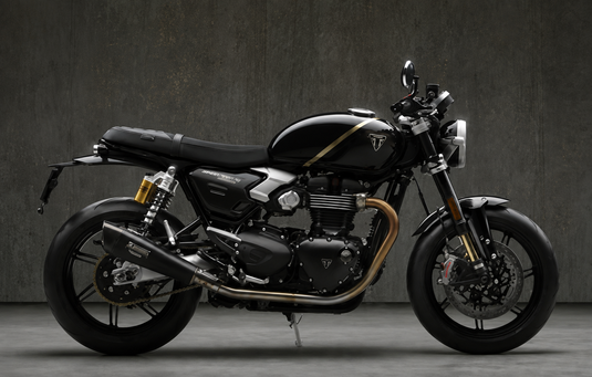 A black 2027 Triumph Speed Twin 1200 TFC motorcycle with gold accents, shown in a side profile against a dark textured studio background.