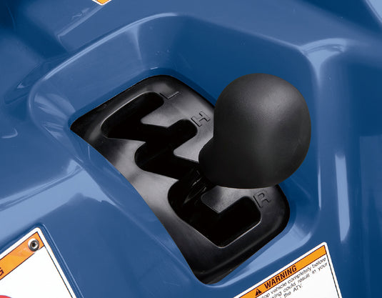 Close-up of a black manual gear shift knob inserted into a black shift tunnel of a blue atv body.