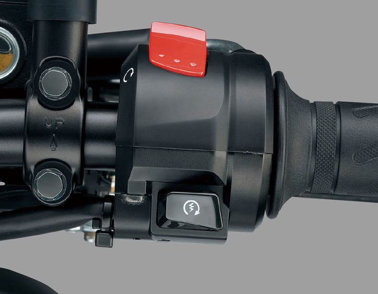 Load image into Gallery viewer, Close-up of a motorcycle handlebar control assembly with a black switch housing, a red quick-start switch, and a black handlebar grip on a gray background.
