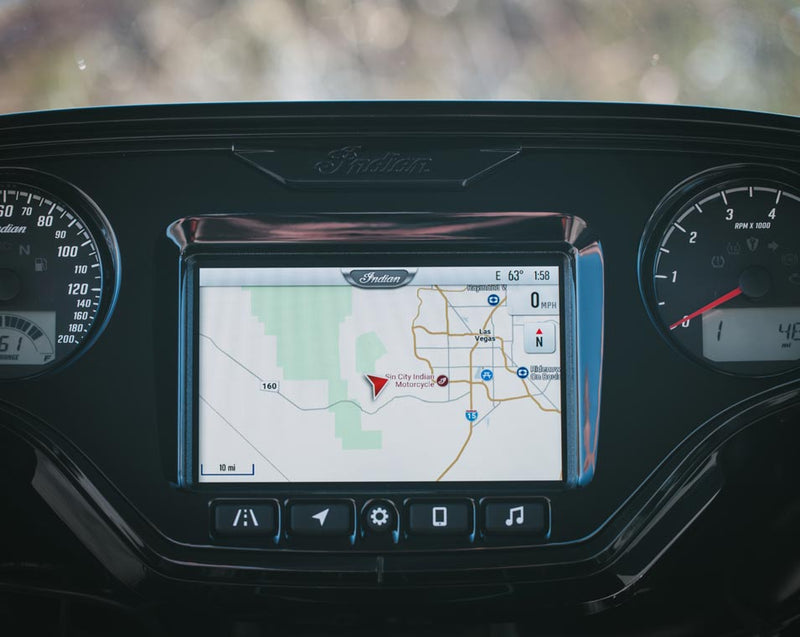 Load image into Gallery viewer, A close-up of a 2026 Indian Roadmaster Dark Horse dashboard display screen showing a navigation map, framed by instrument gauges and a black console with a visible Indian logo above.
