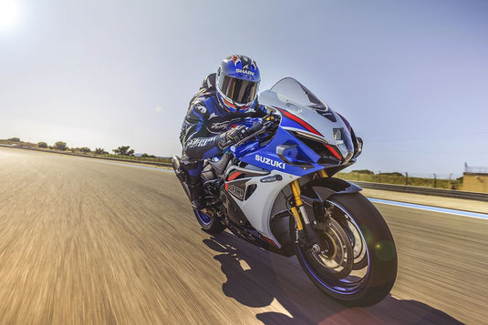 Motorcycle racer on a 2027 Suzuki GSX-R 1000 R on a track with clear blue sky