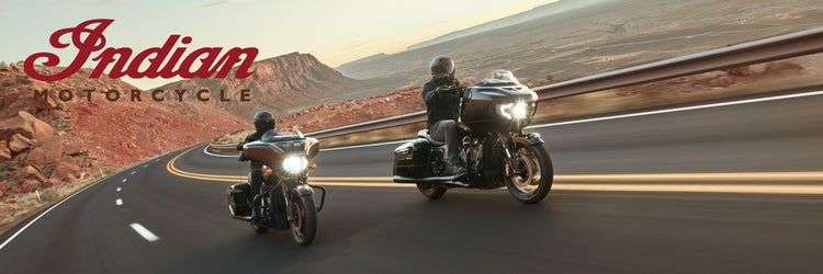 Two people riding Indian motorcycles, available from Cyclespot Group New Zealand, on a desert road with the Indian Motorcycle logo.
