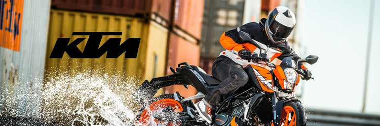Person riding a KTM Duke motorcycle, available from Cyclespot Group New Zealand, through water with shipping containers in the background
